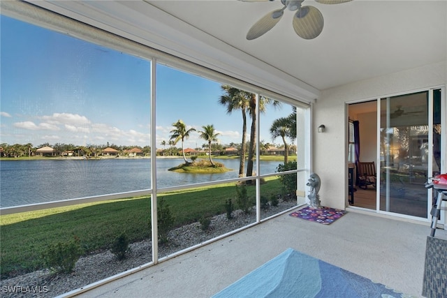 unfurnished sunroom featuring a water view and ceiling fan