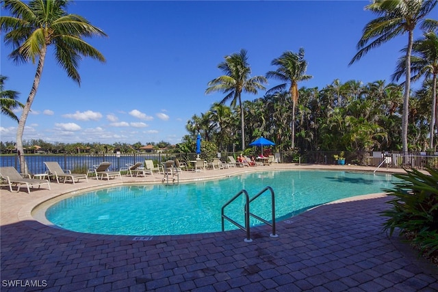 view of pool with a patio and a water view