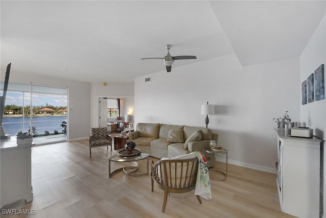 living area with baseboards, a ceiling fan, visible vents, and light wood-style flooring
