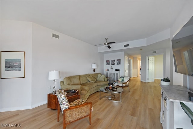living room with light wood-style floors, visible vents, and ceiling fan