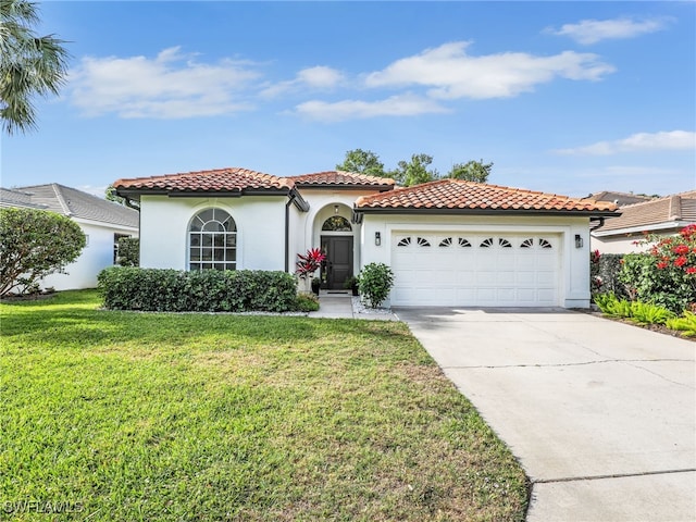 8850 Springwood Ct, Bonita Springs, FL 34135 - mediterranean / spanish-style home featuring an attached garage, a tile roof, a front lawn, and driveway