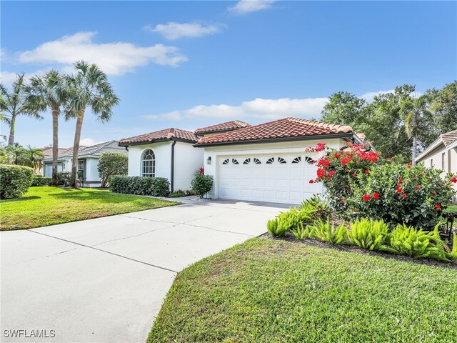 8850 Springwood Ct, Bonita Springs, FL 34135 - mediterranean / spanish home with concrete driveway, stucco siding, an attached garage, a tiled roof, and a front yard