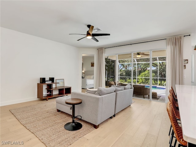 8850 Springwood Ct, Bonita Springs, FL 34135 - living area with baseboards, a sunroom, ceiling fan, and light wood-style flooring