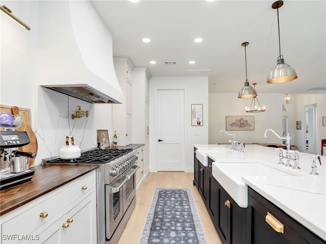 8850 Springwood Ct, Bonita Springs, FL 34135 - kitchen featuring visible vents, custom exhaust hood, a sink, stainless steel range, and dark cabinetry