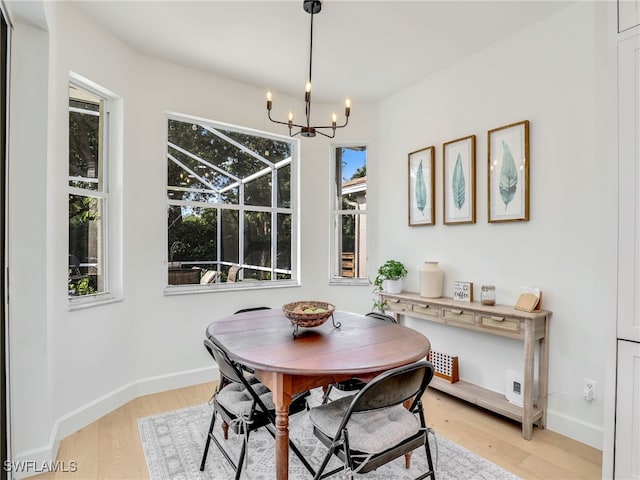 8850 Springwood Ct, Bonita Springs, FL 34135 - dining space featuring baseboards, a wealth of natural light, a chandelier, and light wood-type flooring