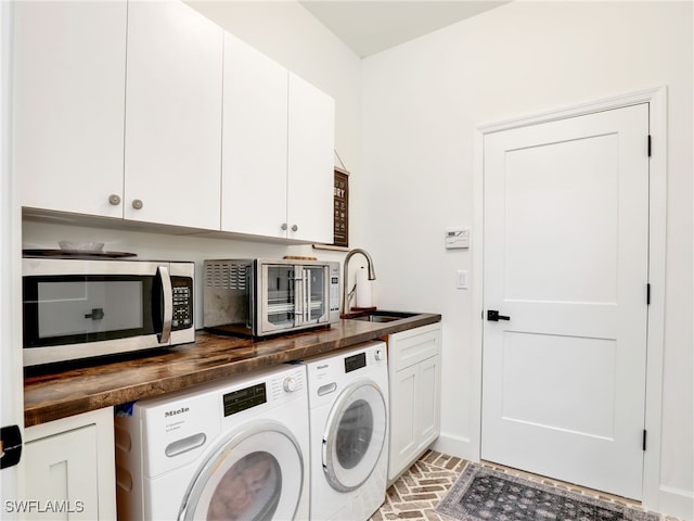 8850 Springwood Ct, Bonita Springs, FL 34135 - clothes washing area with brick floor, washer and dryer, cabinet space, and a sink