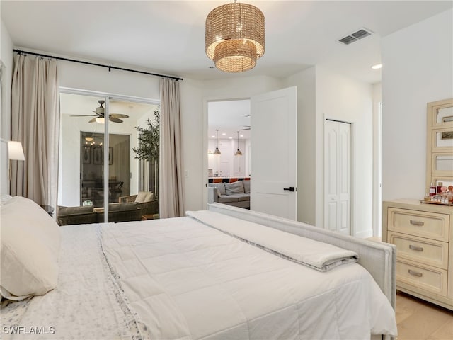 8850 Springwood Ct, Bonita Springs, FL 34135 - bedroom with a notable chandelier, access to outside, light wood finished floors, and visible vents