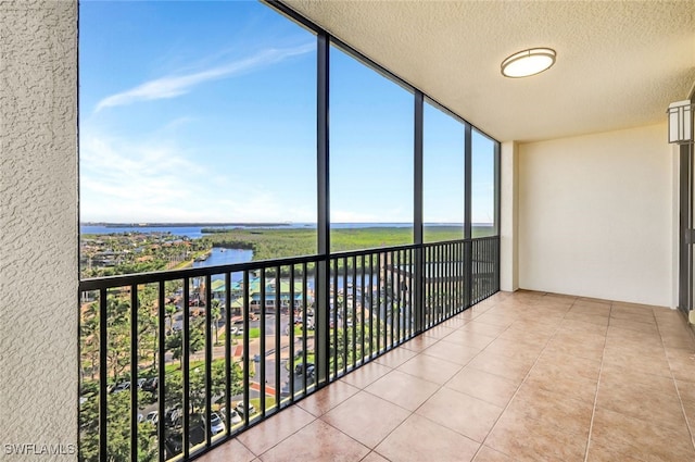 unfurnished sunroom with a water view