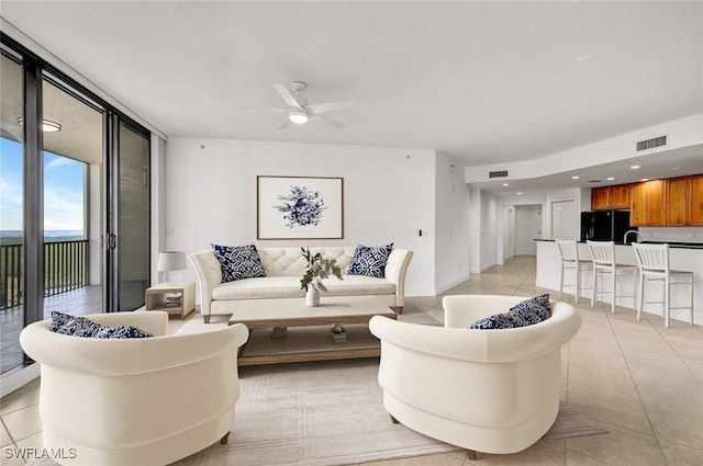 living room with expansive windows, ceiling fan, and light tile patterned floors