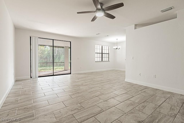 unfurnished room featuring ceiling fan with notable chandelier