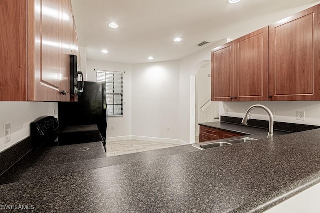 kitchen featuring black range with electric cooktop, kitchen peninsula, and sink