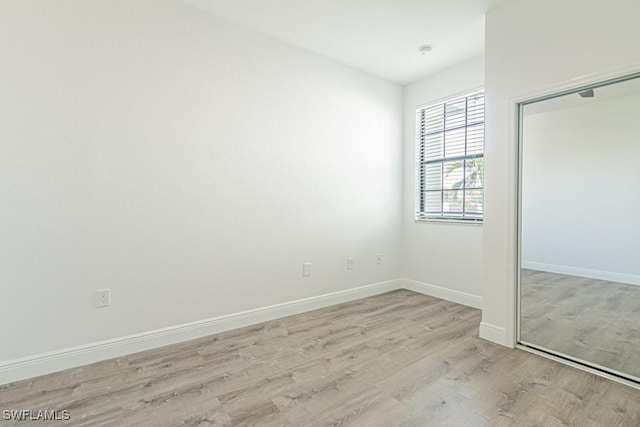 unfurnished bedroom with a closet and light wood-type flooring