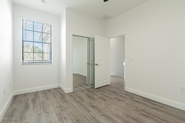 unfurnished bedroom featuring hardwood / wood-style flooring and a closet