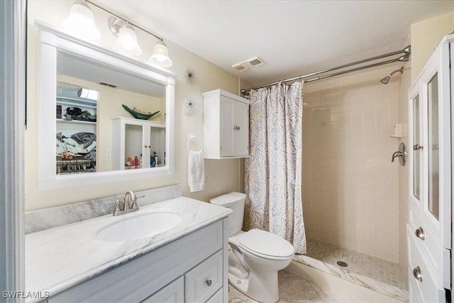 bathroom with visible vents, toilet, a shower stall, and vanity