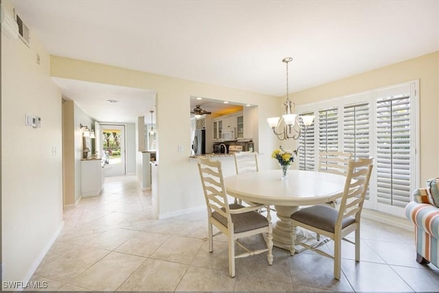 dining space featuring light tile patterned floors, ceiling fan with notable chandelier, visible vents, and baseboards