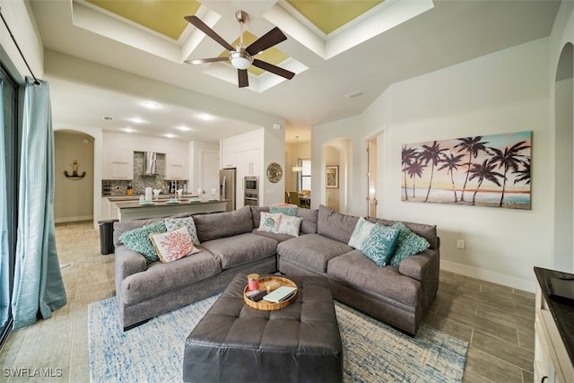 living room featuring coffered ceiling and ceiling fan