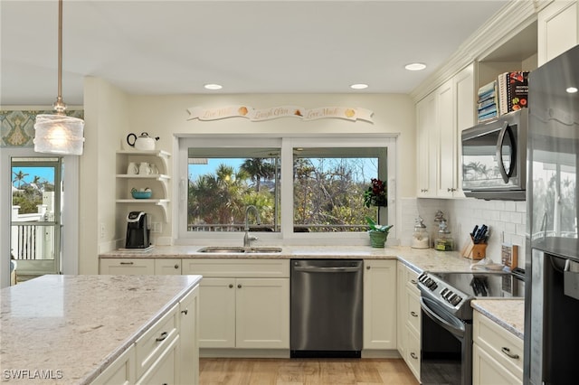 kitchen featuring sink, stainless steel appliances, light stone countertops, decorative backsplash, and decorative light fixtures