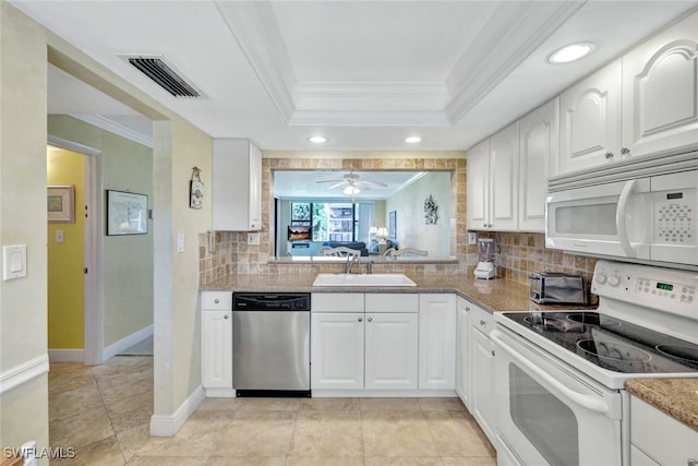 kitchen featuring sink, white cabinets, a raised ceiling, crown molding, and white appliances