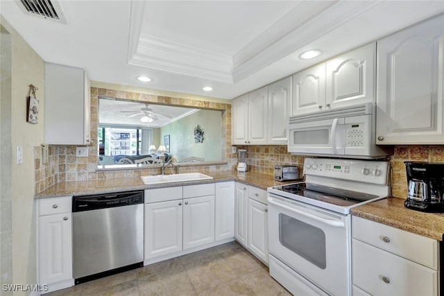 kitchen featuring sink, white cabinetry, ornamental molding, a raised ceiling, and white appliances