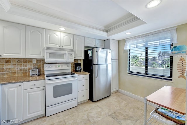 kitchen featuring white appliances, ornamental molding, a raised ceiling, and white cabinets