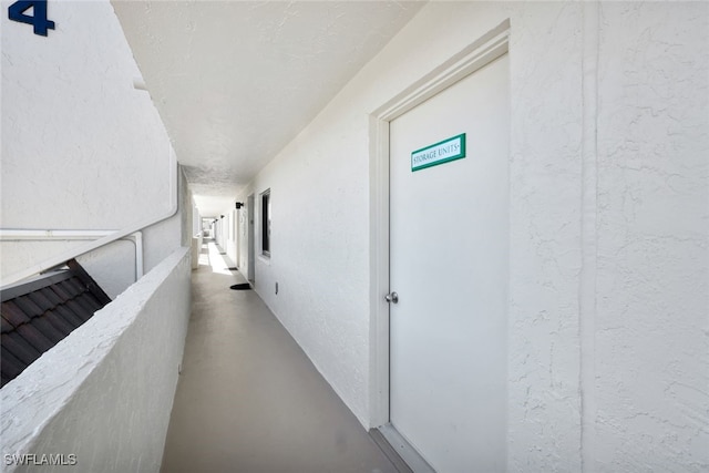 hallway with concrete flooring and a textured ceiling