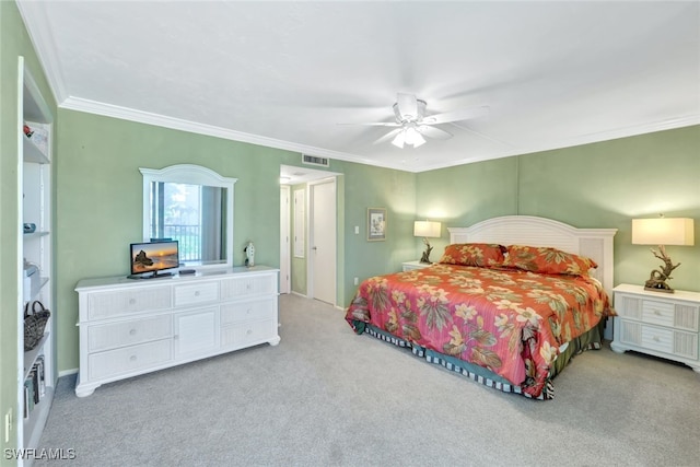 carpeted bedroom with ornamental molding and ceiling fan