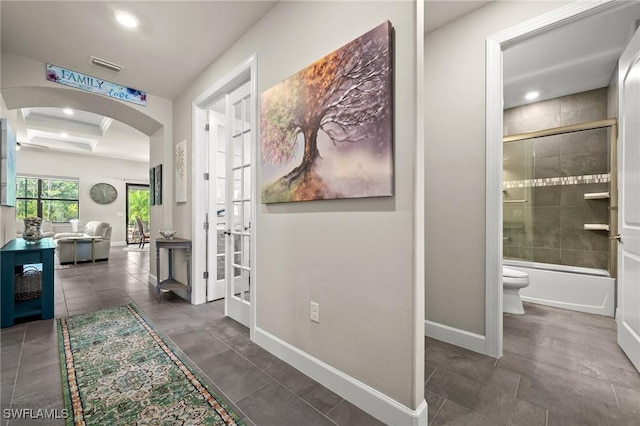 corridor with visible vents, arched walkways, baseboards, and recessed lighting