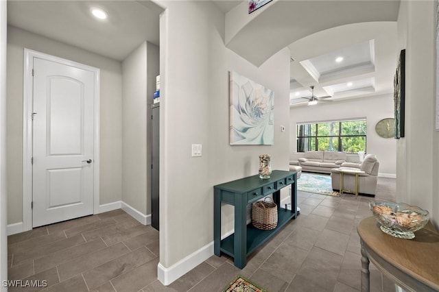 hallway with baseboards, coffered ceiling, arched walkways, beamed ceiling, and recessed lighting