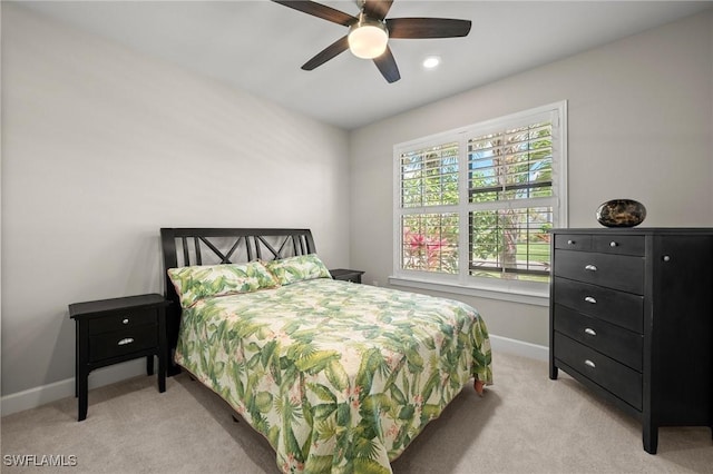 bedroom featuring light colored carpet, ceiling fan, and baseboards