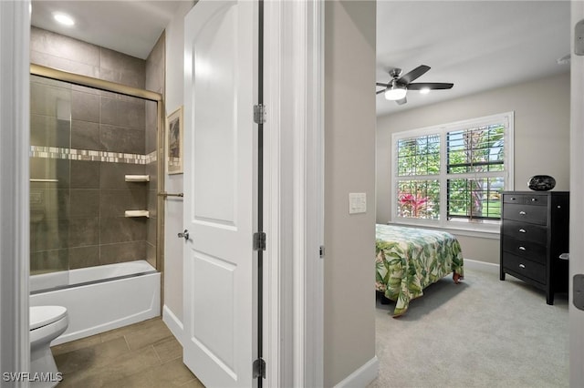 ensuite bathroom featuring shower / bath combination with glass door, toilet, ceiling fan, ensuite bath, and baseboards