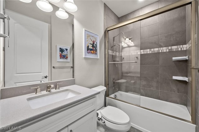 bathroom featuring enclosed tub / shower combo, vanity, and toilet