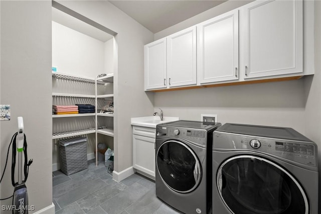 laundry room with washer and dryer, cabinet space, a sink, and baseboards