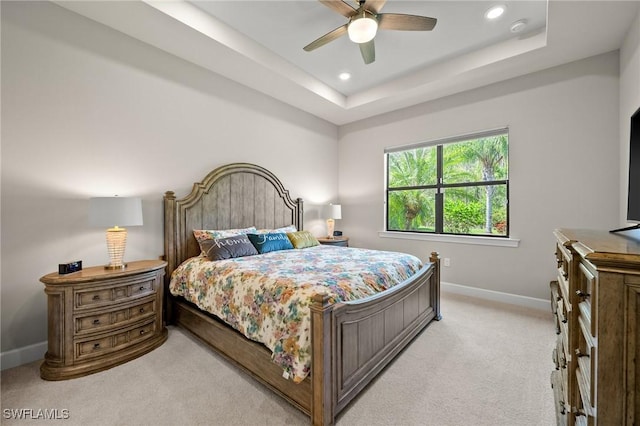 bedroom featuring recessed lighting, a raised ceiling, light colored carpet, and baseboards