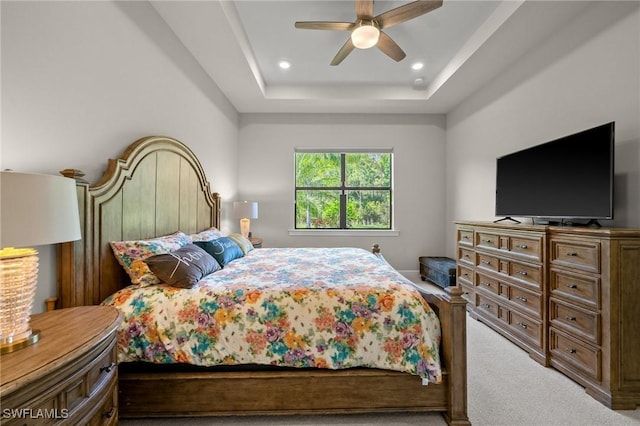 carpeted bedroom with ceiling fan, a tray ceiling, and recessed lighting