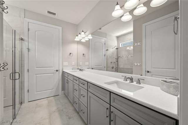 bathroom featuring double vanity, a shower stall, and a sink