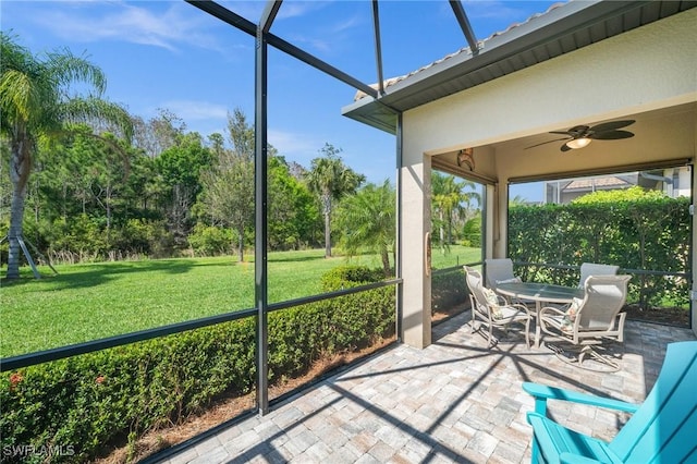 unfurnished sunroom with a ceiling fan and a healthy amount of sunlight