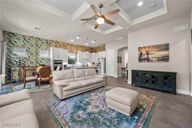 living area featuring arched walkways, coffered ceiling, visible vents, and baseboards