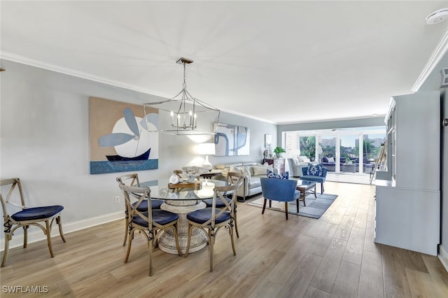 dining space featuring ornamental molding, a chandelier, and light wood-type flooring