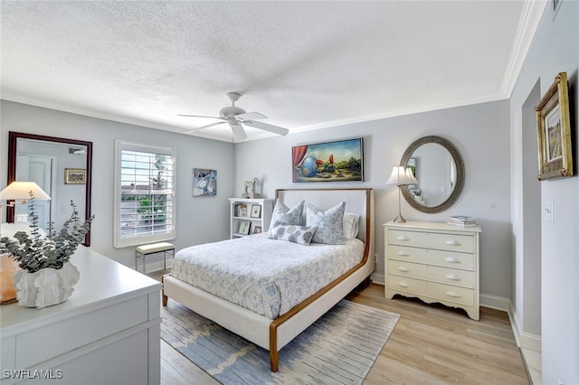 bedroom with ornamental molding, ceiling fan, a textured ceiling, and light hardwood / wood-style floors