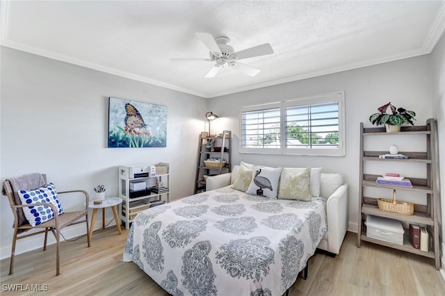 bedroom with crown molding, a textured ceiling, and light wood-type flooring