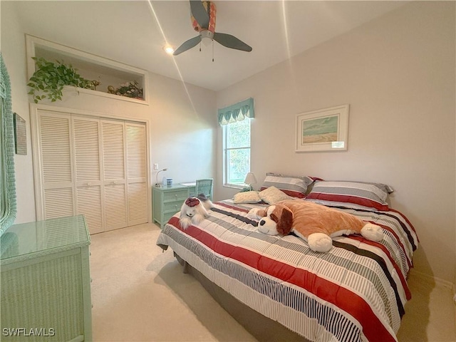 carpeted bedroom featuring ceiling fan and a closet