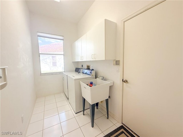 washroom featuring cabinets, washer and dryer, and light tile patterned flooring