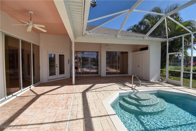 view of pool featuring glass enclosure, a patio area, ceiling fan, and french doors