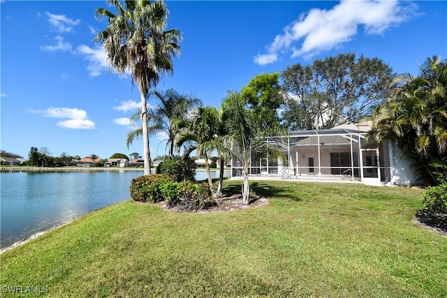 view of yard with a water view and glass enclosure