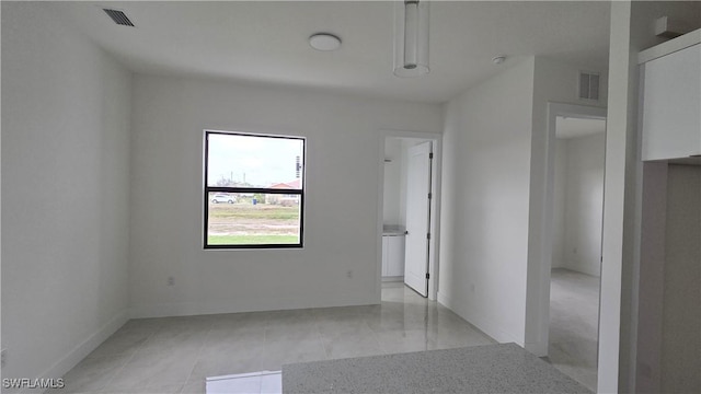 empty room with visible vents and baseboards