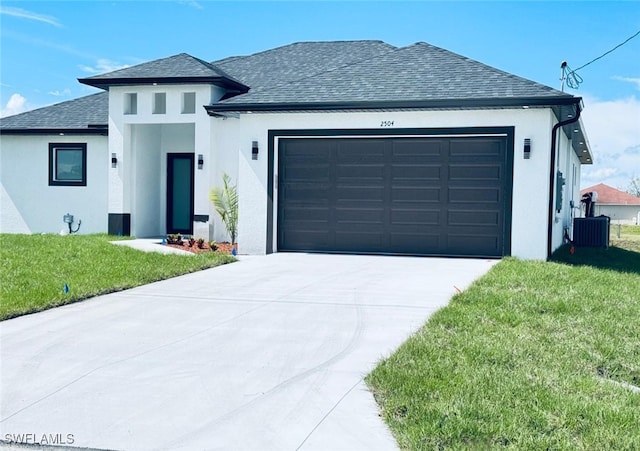 prairie-style home with an attached garage, driveway, roof with shingles, stucco siding, and a front yard