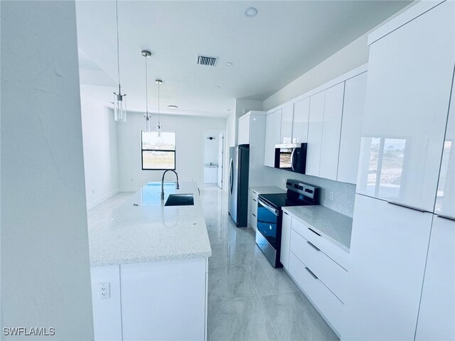 kitchen with stainless steel appliances, a sink, visible vents, white cabinetry, and modern cabinets