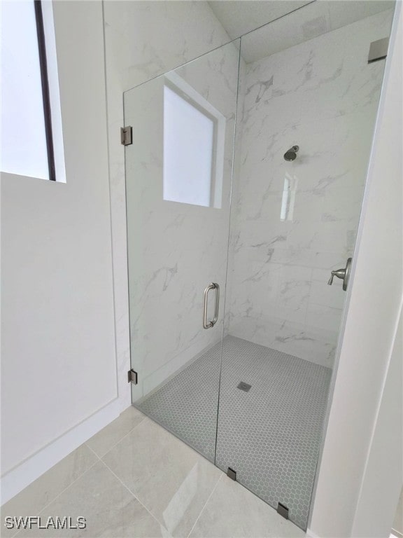 full bathroom featuring tile patterned flooring and a marble finish shower