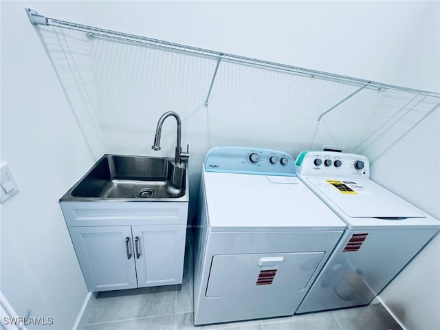 clothes washing area featuring cabinet space, a sink, and separate washer and dryer