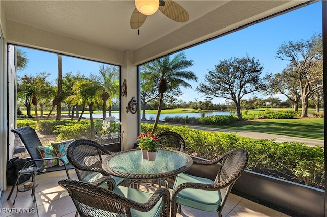 sunroom with a water view and ceiling fan